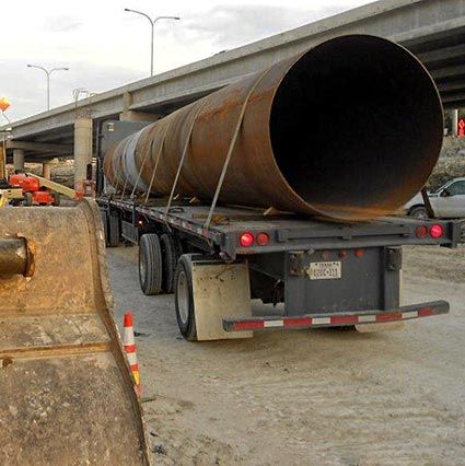 Road Bore Casing Pipe on semi-truck trailer near highway